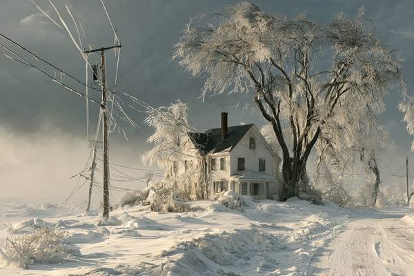 New England colonial home buried in a nor'easter with ice-coated trees and downed power lines