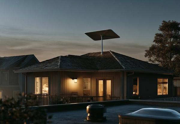 Starlink satellite dish on rooftop at night with warm house lights glowing below